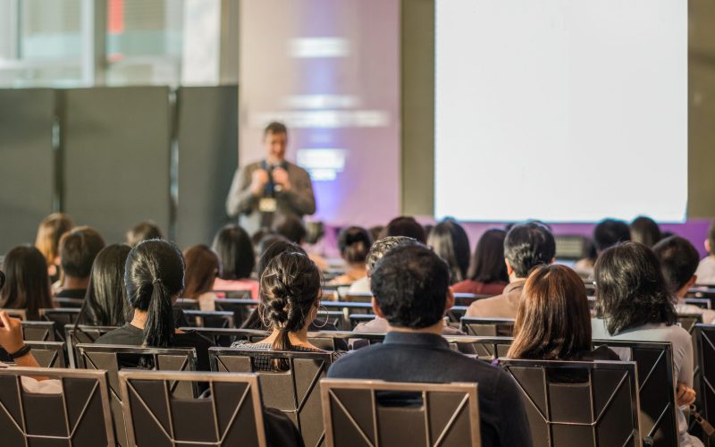 Rear view of Audience in the conference hall or seminar meeting which have speaker